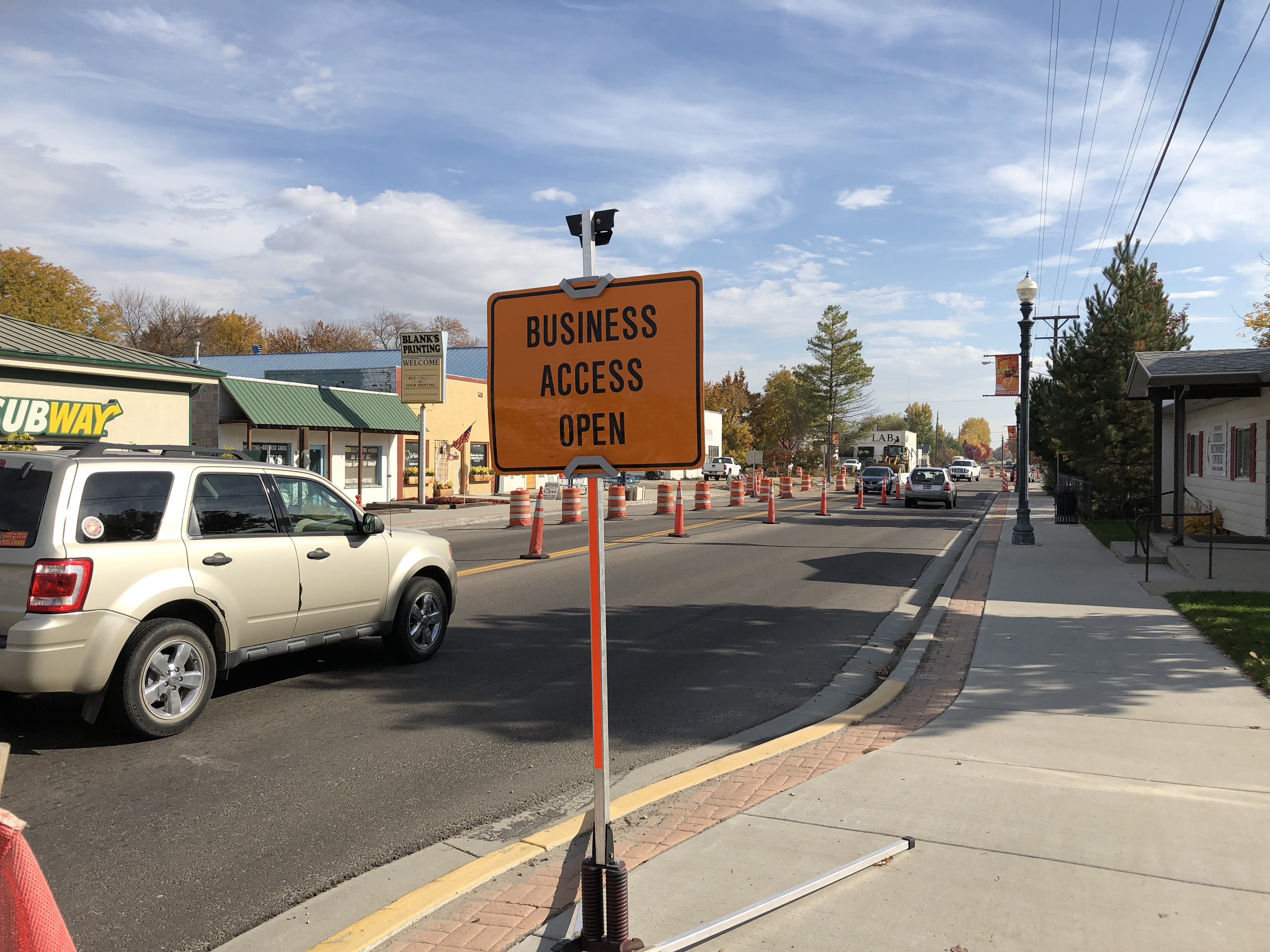 Temporary business access construction sign on sidewalk.